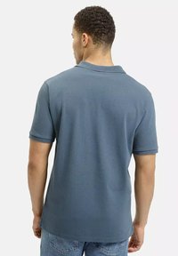 Męska koszulka polo w ciemnoniebieskim kolorze, z krótkim rękawem, o regularnym kroju, wykonana z bawełny. Posiada klasyczny kołnierzyk i gładką fakturę.