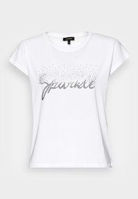 Camiseta de algodón blanca con mangas cortas que presenta un diseño de texto "sparkle" en brillantes de metal, dispuestos en un patrón de degradado.