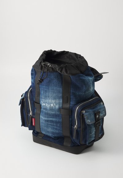 Rucsac din denim cu inchidere cu sfoară, accente negre, două buzunare laterale cu fermoar și o bază robustă. Finisaj texturat cu detalii de estompare ușoară.