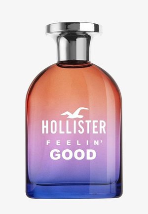Glas parfume flaske med gradient farver fra orange til lilla, sølv låg, mærket "Hollister Feelin' Good" med fuglelogo.