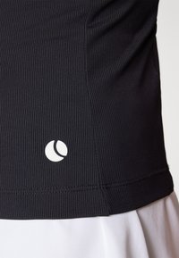 Melnas ribotas auduma blūze ar baltu logotipu apakšmalā. Dizains ir pieguļošs, ar gludu tekstūru un minimālistisku stilu.