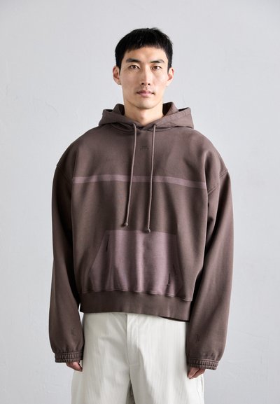 Brown hooded sweatshirt featuring a textured finish, a horizontal stripe across the chest, a front pocket, and a relaxed fit.