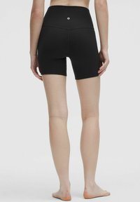 Schwarze hochgeschnittene Shorts mit einem strukturierten Muster und Logodetail auf der Rückseite. Der Stoff ist glatt und hat eine angenehme Passform.