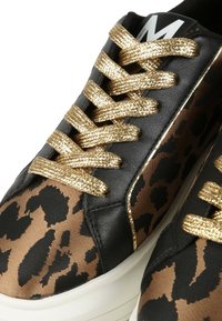 Sneaker nere e oro con tomaia a stampa leopardata, lacci metallici oro e suola in gomma bianca con un accento di design sottile.