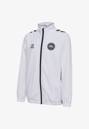 Hvid jakke med høj krave, sort lynlås og elastiske manchetter. Har sorte detaljer på skuldrene og et rundt logo på brystet.
