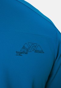 Blauer strukturierter Stoff mit schwarzer Umrisszeichnung von drei Bergen und dem Text "together out there" auf der Rückseite gedruckt.