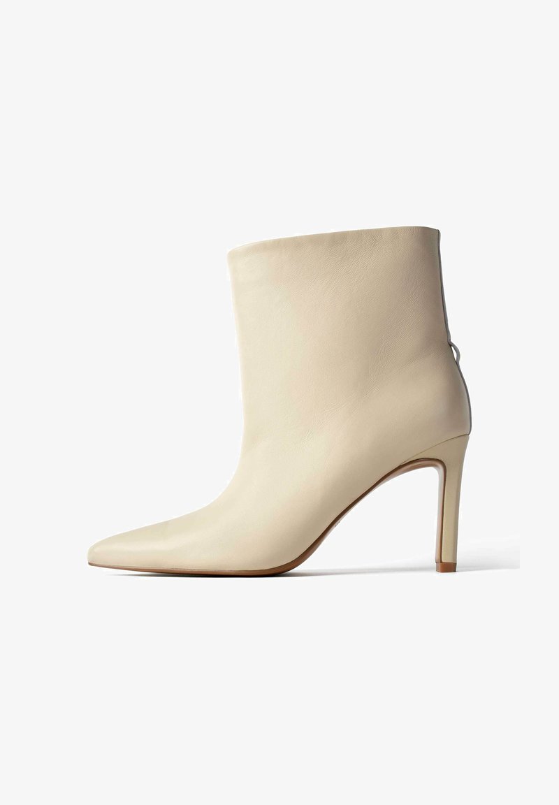 Kreemvärvi nahast ankle-boot, millel on terav nina, peen stiletto konts ja sile tekstuur; lisadetailiks on peen tagumine õmblus.