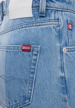 Jeans in denim azzurro con etichette rosse "Big Star" sulle tasche posteriori e una toppa in pelle bianca in vita. Design classico a cinque tasche.
