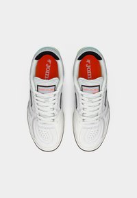 Λευκά αθλητικά παπούτσια με διάτρητο σχέδιο, μαύρες λεπτομέρειες και κόκκινη εσωτερική σόλα με την ένδειξη "TOP-FLEX." Τα κορδόνια είναι λευκά και η σόλα είναι ανοιχτόχρωμη.