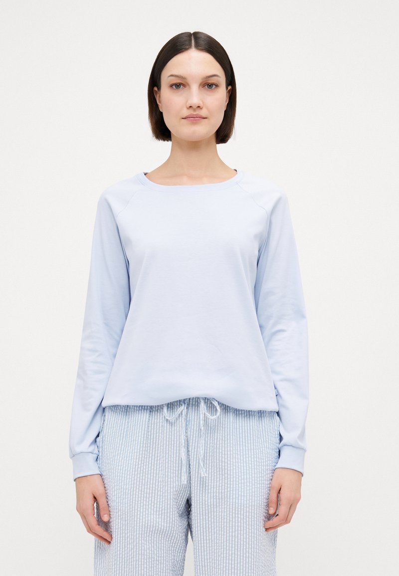Ljusblå långärmad sweatshirt med rund hals och raglanärmar, kombinerad med ljusblå randiga pyjamasbyxor med dragsko.