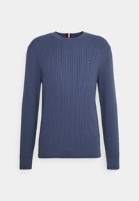Maglione a coste di colore blu navy, con maniche lunghe, scollatura rotonda e piccolo logo sul petto. Tessuto texturizzato e polsini aderenti.