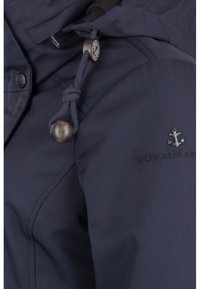 Granatowa wodoodporna kurtka z kapturem, regulowanym sznurkiem, drewnianym zapięciem i haftowanym logo kotwicy na piersi. Gładka tekstura materiału.