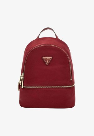 Zaino in tela rossa con forma arrotondata, cerniera dorata e patch logo triangolare. Presenta una maniglia superiore e una tasca frontale con zip.