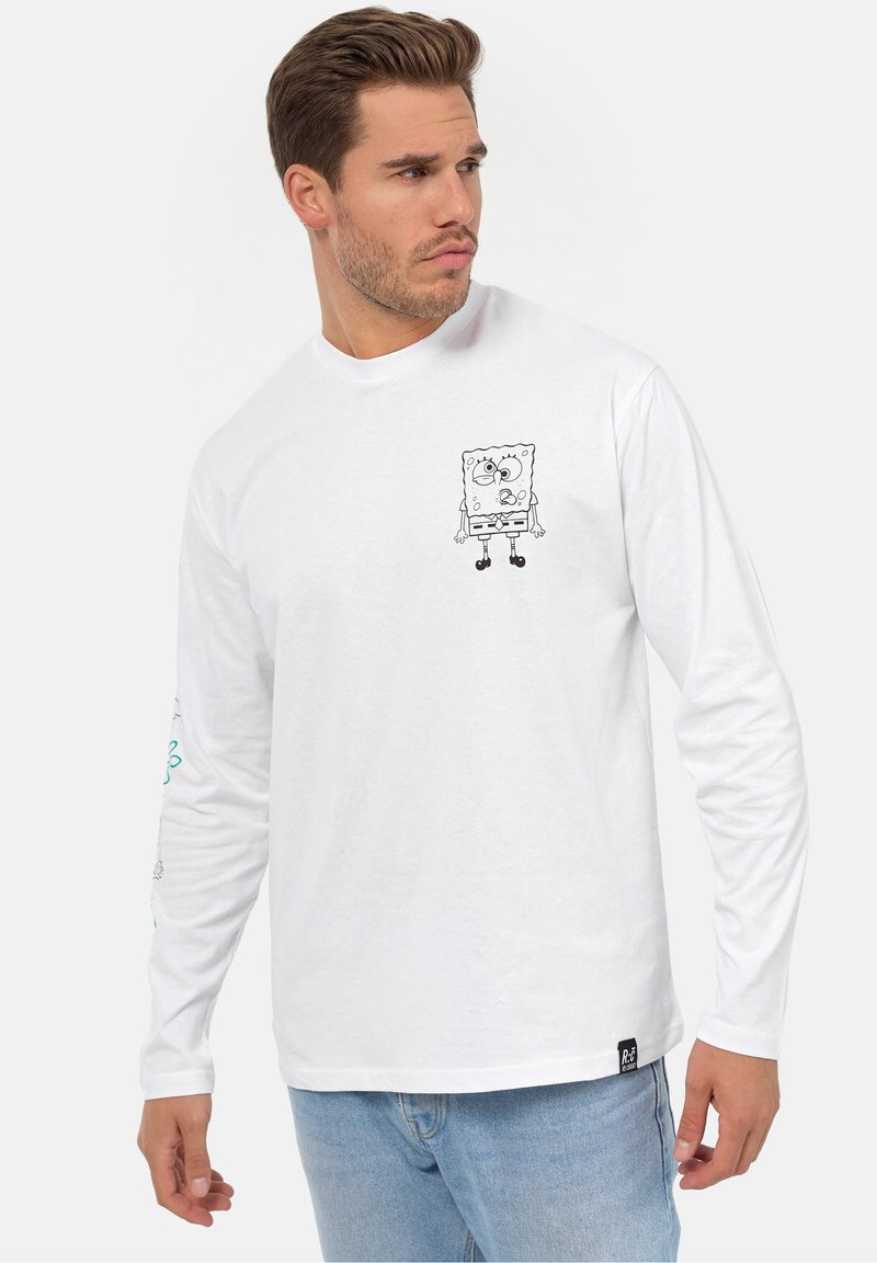 Hvid langærmet t-shirt med en sort omridsillustration af en tegneseriefigur på framsiden og dekorative elementer på ærmerne.