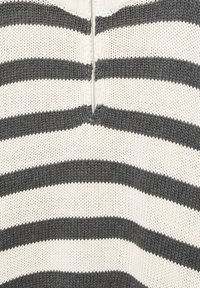 Strickpullover mit abwechselnd schwarzen und weißen horizontalen Streifen, sichtbarem Reißverschluss und strukturiertem Stoff.