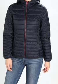 Mörkblå puffjacka med dragkedja fram, huva och quiltad design. Har kontrasterande rosa dragkedja och elastiska ärmslut.