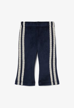 Pantaloni in velluto a coste blu navy con gambe svasate, caratterizzati da due strisce verticali in pizzo color crema lungo i lati e una finitura morbida e testurizzata.