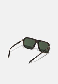 Óculos de sol quadrados com lentes verde-escuras, armação de tartaruga, design elegante e detalhes em dourado nas hastes. Braços texturizados para melhor aderência.