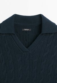 Marineblå kabelstrikket sweater med en foldet krave og V-hals, med et "Massimo Dutti" mærke lavet i Tyrkiet.
