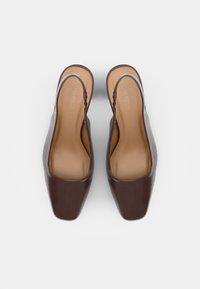 Ruske nahkaste slingback petice s kvadratnim vrhom, gladko teksturo in minimalističnim dizajnom. Imajo bež podplat in diskretno blagovno znamko znotraj.