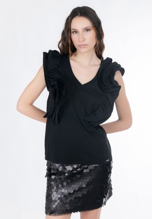 Top nero con scollo a V e maniche corte arricciate; abbinato a una gonna midi nera con paillettes a cerchio in diverse tonalità di nero.