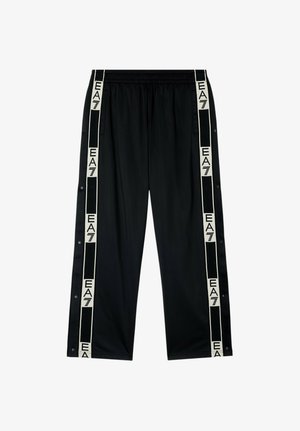 Pantaloni sportivi neri con bottoni a pressione lungo i lati e strisce bianche con il logo EA7 che corrono verticalmente dalla vita all'orlo.