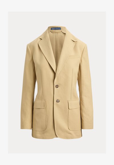 Μπεζ λινό σακάκι με γιακά με χαραγμένο έντομο, κλείσιμο με δύο κουμπιά, δύο μπροστινές τσέπες και μία τσέπη στο στήθος. Λείο ύφασμα, εφαρμοστή γραμμή.