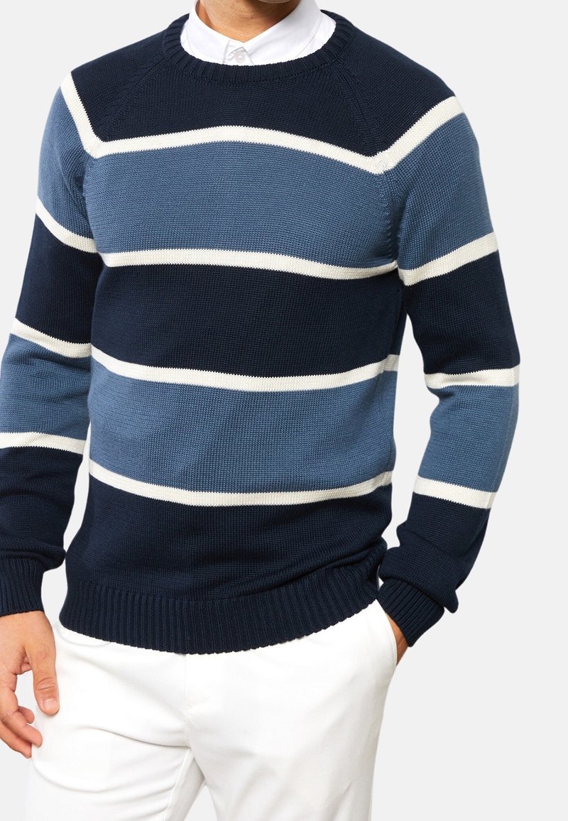 Blå och marinrandig tröja med vita accenter, ribbad krage och ärmslut, stickad textur, rundad nackdesign och avslappnad passform.