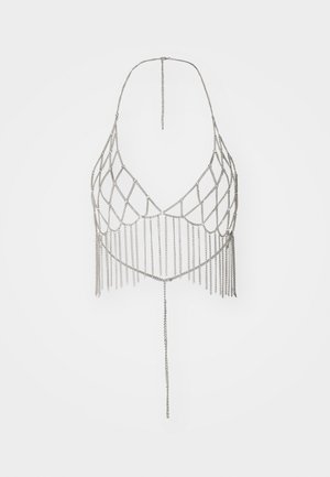 Haut halter en chaîne argentée présentant un design en filet de diamant, avec des détails à franges verticales et une chaîne suspendue au centre.