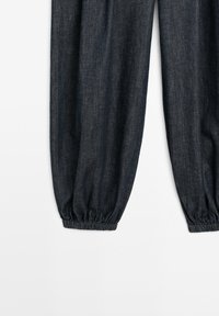 Dark denim jogger pants with elastic cuffs at the ankles, shown from mid-thigh down against a white background.