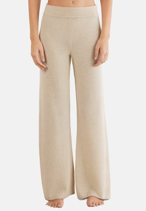 Pantalons à jambes larges en tricot beige doux. Dotés d'une ceinture lisse et d'une finition texturée, offrant une coupe décontractée et une silhouette fluide.