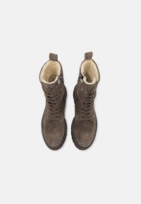 Brūni zamšveida potīšu zābaki ar mākslīgo kažokādu iekšpusē, saistāma priekšpuse un sānu rāvējslēdzis, kas nodrošina ērtu piekļuvi. Bieza gumijas zole labākai saķerei.