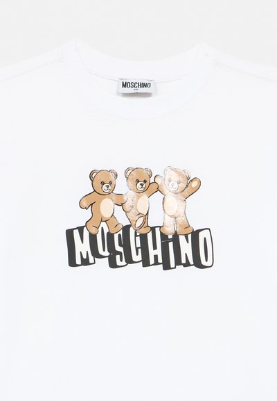 T-shirt blanc Moschino Kids avec trois oursons marron se tenant la main au-dessus du logo Moschino en lettres majuscules.