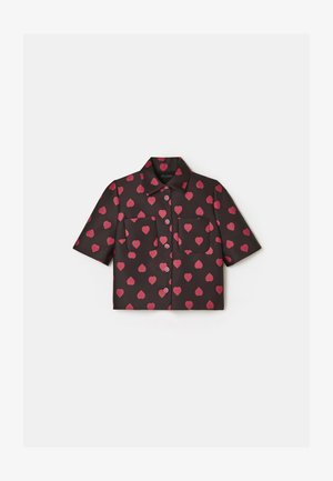 Chemise à manches courtes en tissu noir avec un motif de cœurs roses, design avec col, deux poches avant et fermeture centrale par bouton.