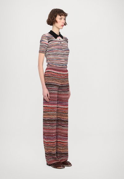 Top in maglia con colletto nero, caratterizzato da strisce orizzontali multicolori; abbinato a pantaloni alla zuava a righe in tonalità simili.
