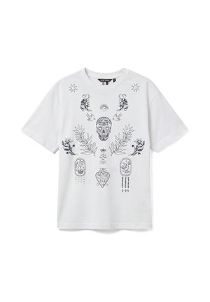 T-shirt blanc à manches courtes avec des motifs noirs complexes comprenant un crâne de sucre, des tigres, des étoiles, des plantes et des symboles abstraits sur le devant.