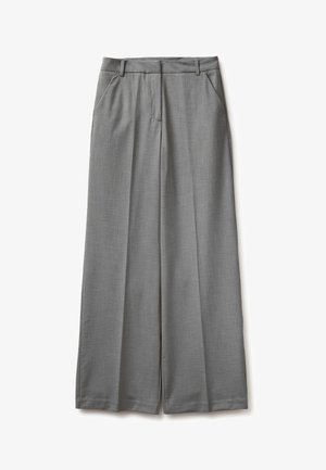 Šedé široké kalhoty s předními záhyby, poutky na pásek a postranními kapsami, položeny na bílém pozadí.