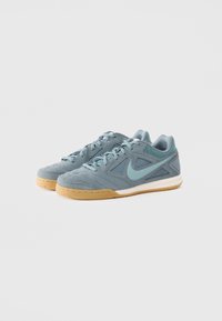 Blue suede athletic shoes featuring a textured design, light blue accents, and a gum rubber sole; lace-up style with mesh areas.