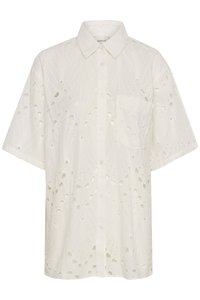 Camicia bianca a maniche corte con un motivo a taglio, chiusura con bottoni e una singola tasca sul petto. Realizzata in tessuto leggero.