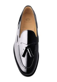 Black leather loafers with a smooth finish, featuring a decorative tassel and a Goodyear-welted construction. Elegant stitching detail along edges.