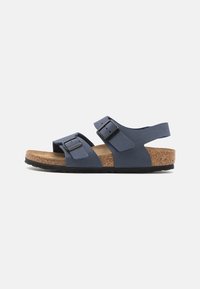 Blå to-rem sandal med justerbare spenner, korkfotseng og svart gummisåle. Mykt semsket materiale med minimalistisk design.