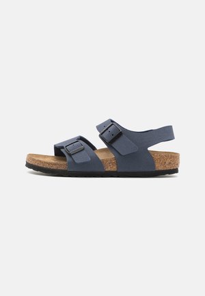 Blå to-rem sandal med justerbare spenner, korkfotseng og svart gummisåle. Mykt semsket materiale med minimalistisk design.
