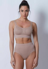 Beige underkläderset som innehåller en mjukkoppsbehå med spetsliknande design och högmidjade trosor med liknande detaljer och varumärke.