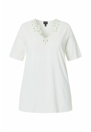 Haut blanc à manches courtes avec encolure en V, orné de découpes décoratives en forme de feuilles le long du col, tissu uni, coupe ample.