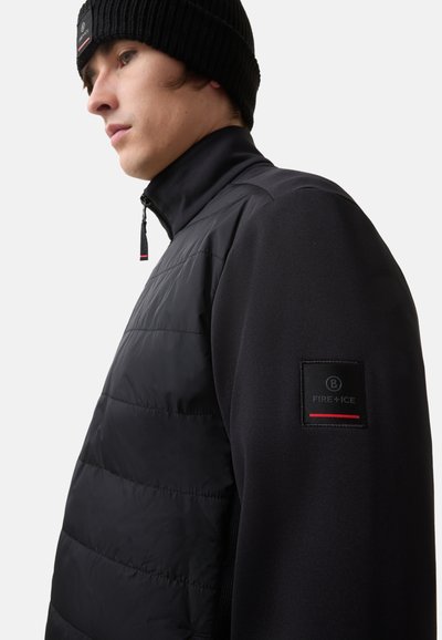 Zwarte jas met een gevoerde voorkant, zachte stofmouwen en een hoge kraag. Inclusief een klein logopatch op de linker mouw.