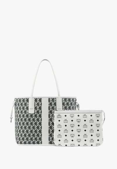 Grande borsa a tote con un motivo geometrico bianco e nero e manici bianchi, accompagnata da una pochette più piccola con un motivo a logo ripetuto.