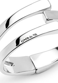 Bague en argent de UNOde50 présentant un design torsadé avec des surfaces lisses et brillantes ainsi qu'un accent angulaire poli.