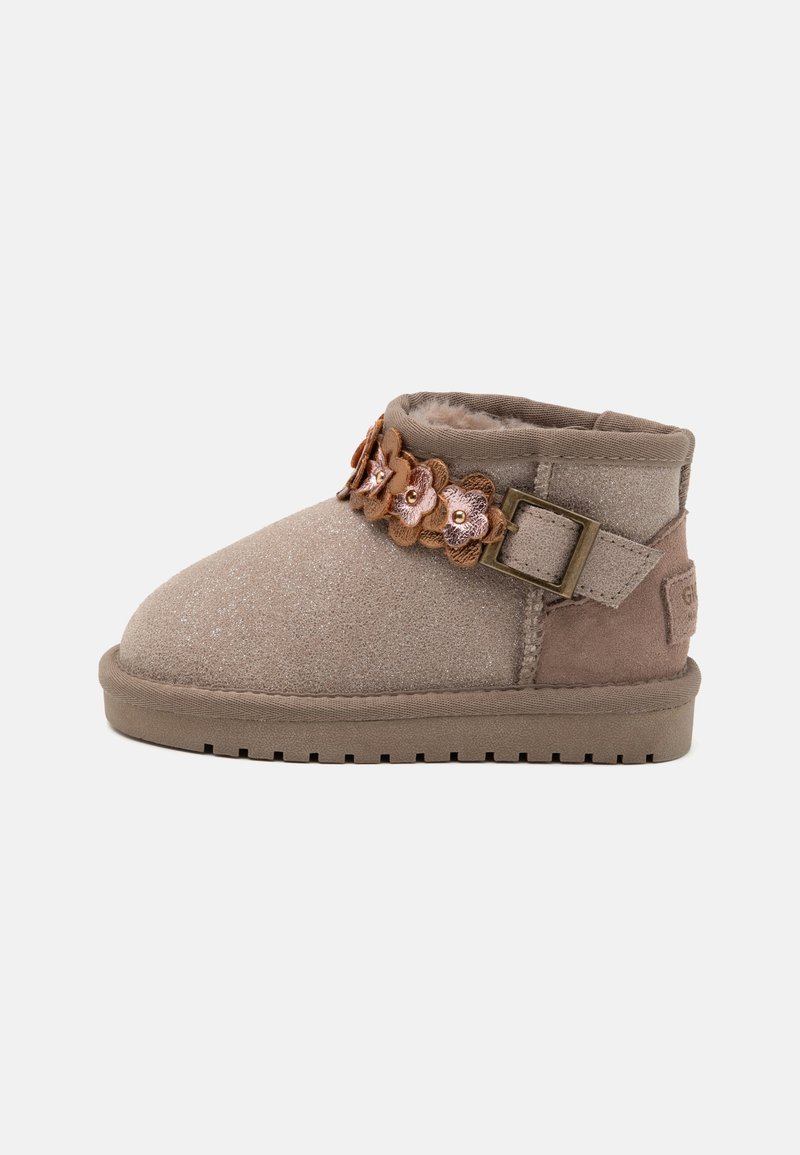 Bottine enfant en suède marron clair avec une bride à boucle ornée d'appliques de fleurs roses et marron, avec une doublure intérieure en fourrure douce.