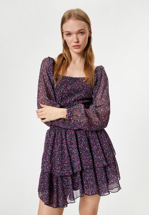 Floral print dress featuring a square neckline, sheer puff sleeves, and layered ruffles in shades of purple, pink, and black.