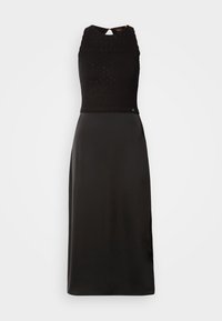 Abito nero con un corpino in maglia testurizzata e una gonna in satin liscia. Senza maniche, con una scollatura alta e un dettaglio a occhio di chiave sulla schiena.